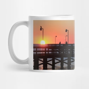 Two fishermen sillouhetted on the pier at sunrise Mug